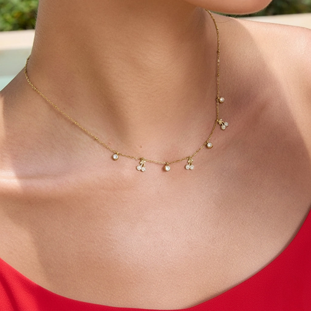 Model draagt een subtiele gouden choker met kersenhanger en zirkonia bedeltjes.