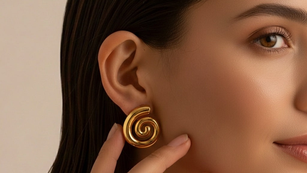 Close-up van een vrouw met een grote gouden spiraal oorbel van CECELYN.