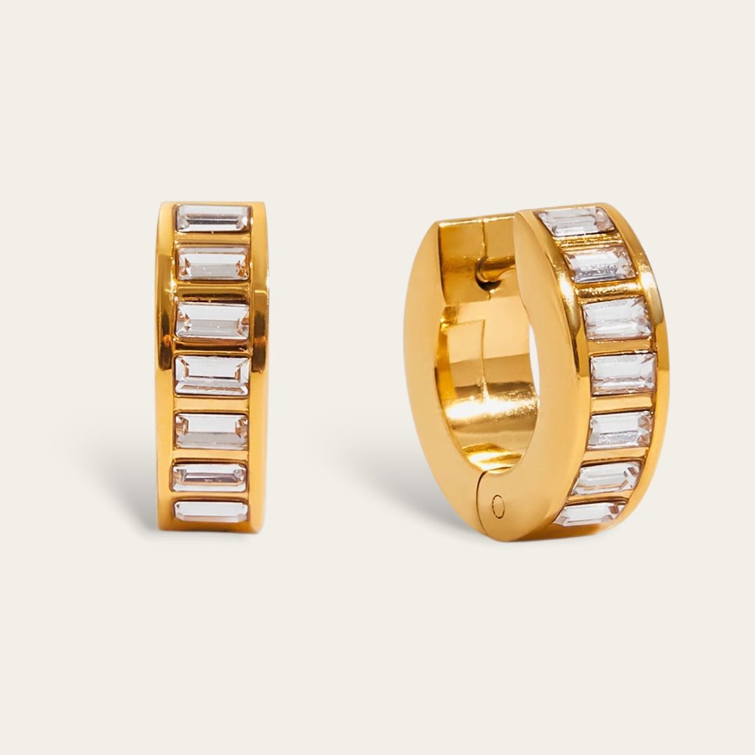 Goudkleurige chunky huggie hoops oorbellen met baguette geslepen zirkonia stenen.