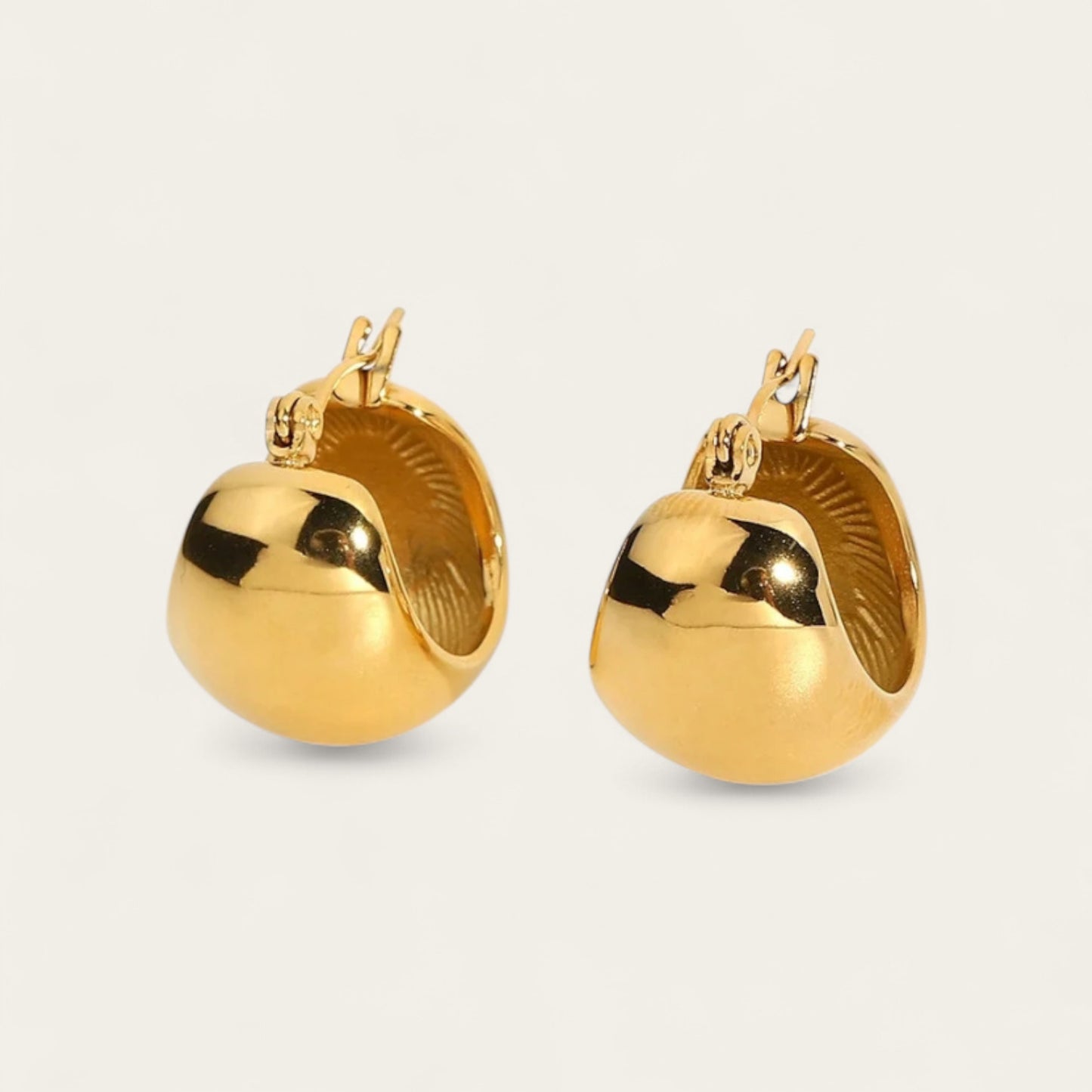 Gouden chunky druppel oorbellen met glanzende afwerking op een lichte achtergrond - minimalistische teardrop hoops voor dames.