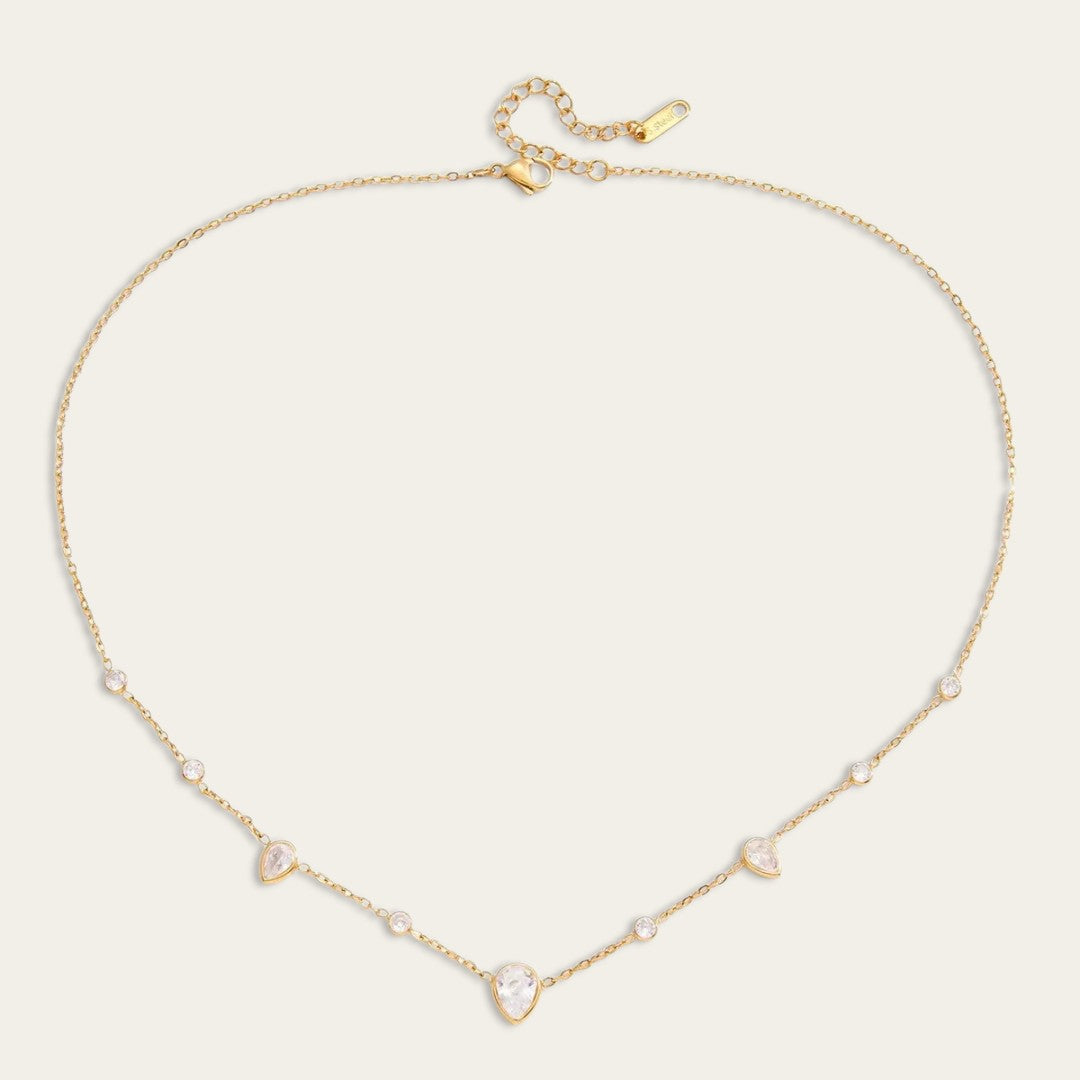 Verfijnde gouden ketting met druppelvormige en ronde kristallen.