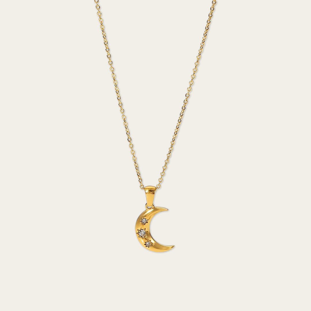 Minimalistische gouden necklace met crescent moon bedeltje en fonkelende details.