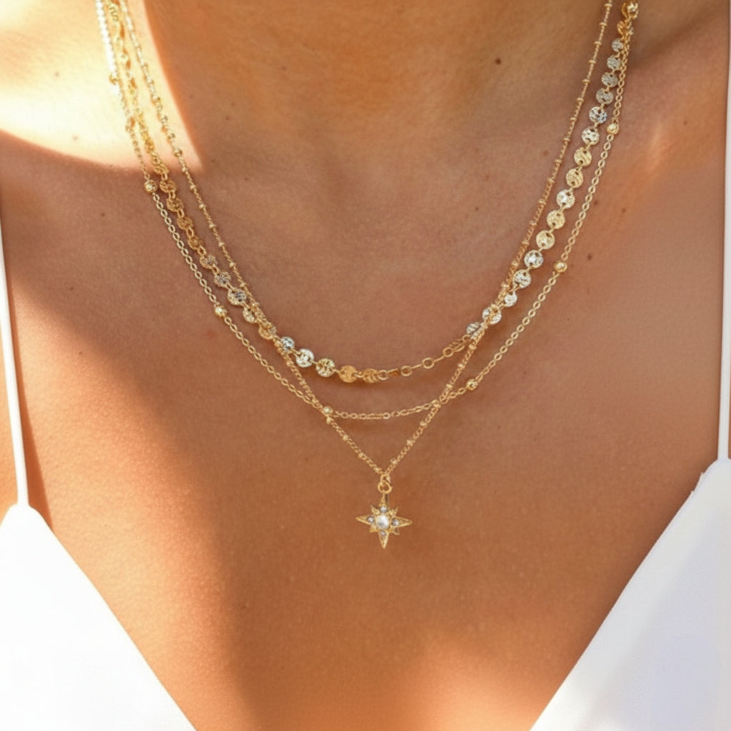 Model draagt een goudkleurige triple-layer ketting met een ster-bedel.