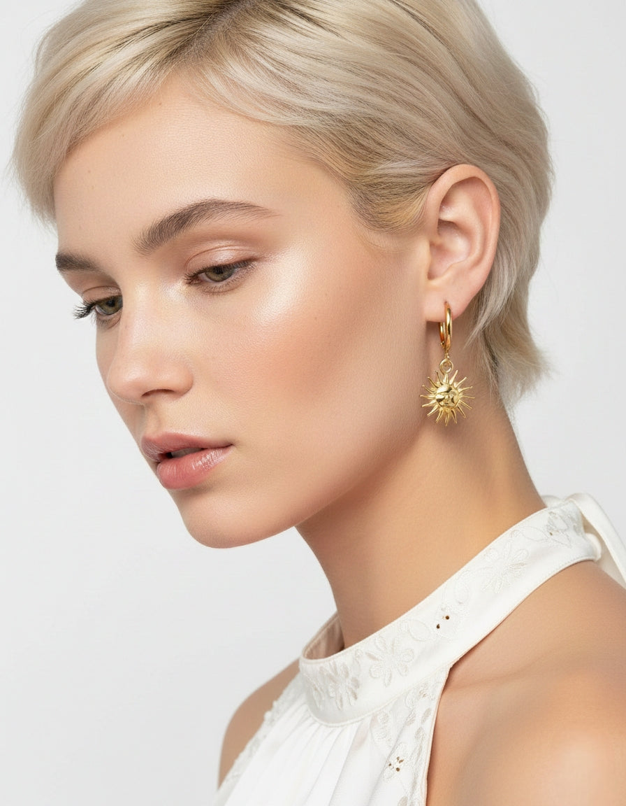 Model draagt minimalistische goudkleurige hoops met een zonnetje in celestial stijl.