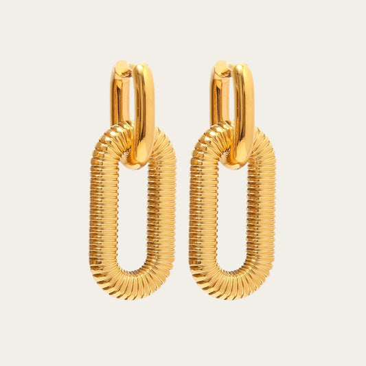 Gouden statement oorbellen bestaande uit een gladde bovenring en een grote, geribbelde ovale schakel.