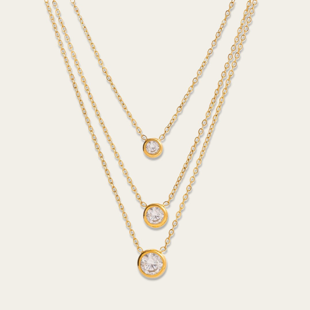 Goudkleurige gelaagde ketting met drie lagen en drie ronde zirkonia steentjes.