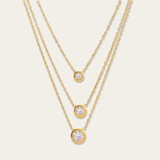 Goudkleurige gelaagde ketting met drie lagen en drie ronde zirkonia steentjes.