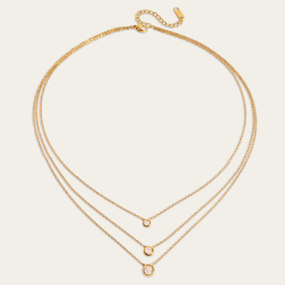 Gelaagde ketting met drie glanzende kristallen in goudkleurige kastzetting.