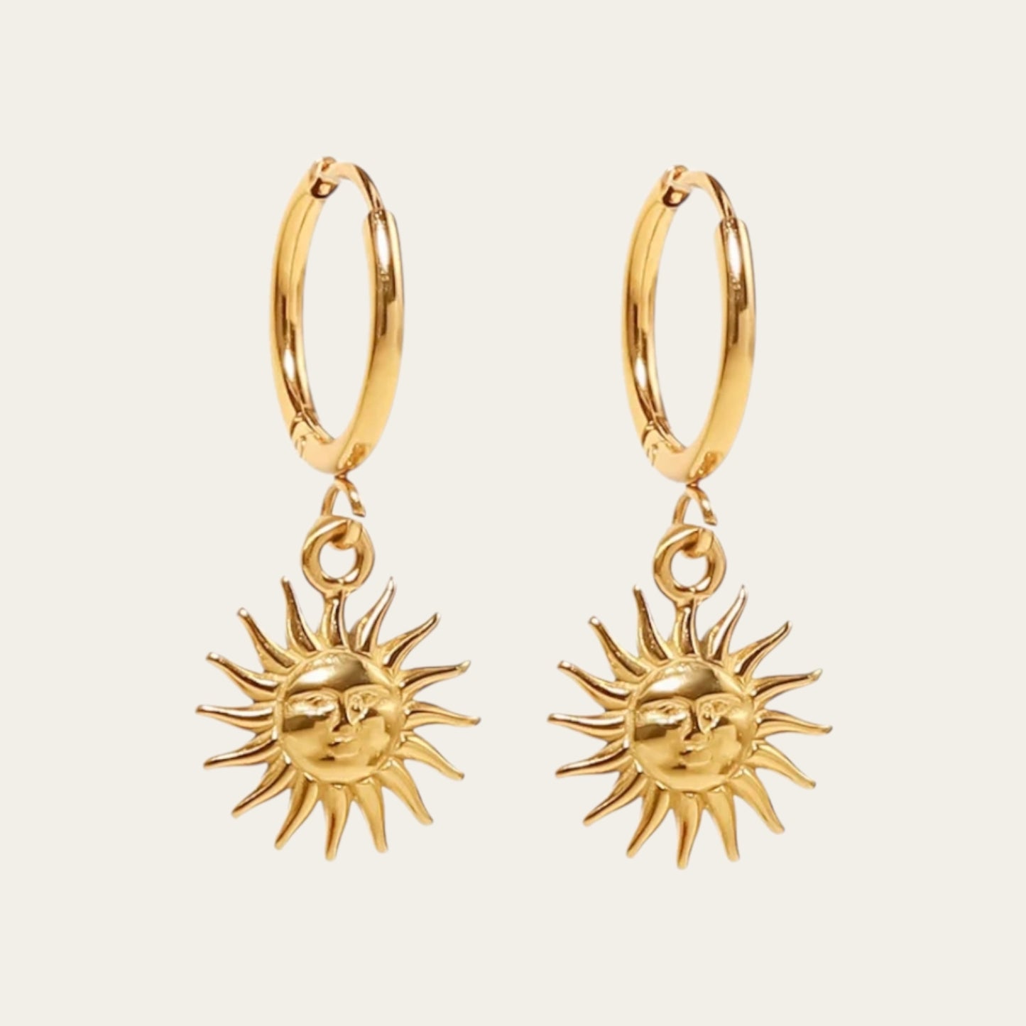 Gouden hoop oorbellen met een gedetailleerde zonne-bedel.