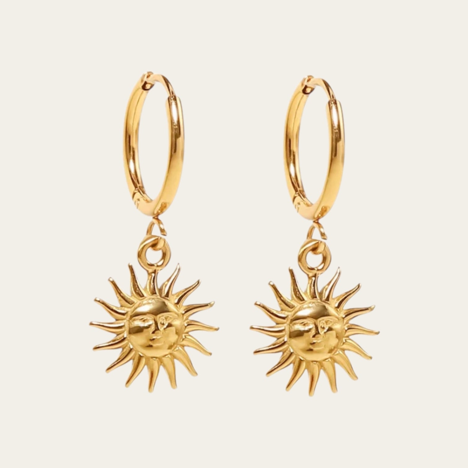 Gouden hoop oorbellen met een gedetailleerde zonne-bedel.