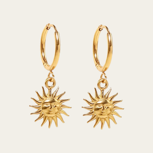 Gouden hoop oorbellen met een gedetailleerde zonne-bedel.